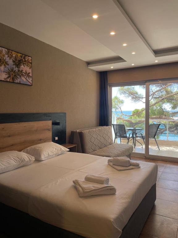 Pokój w Hotelu Vue Mer — łóżko i wyjście na taras z widokiem na morze